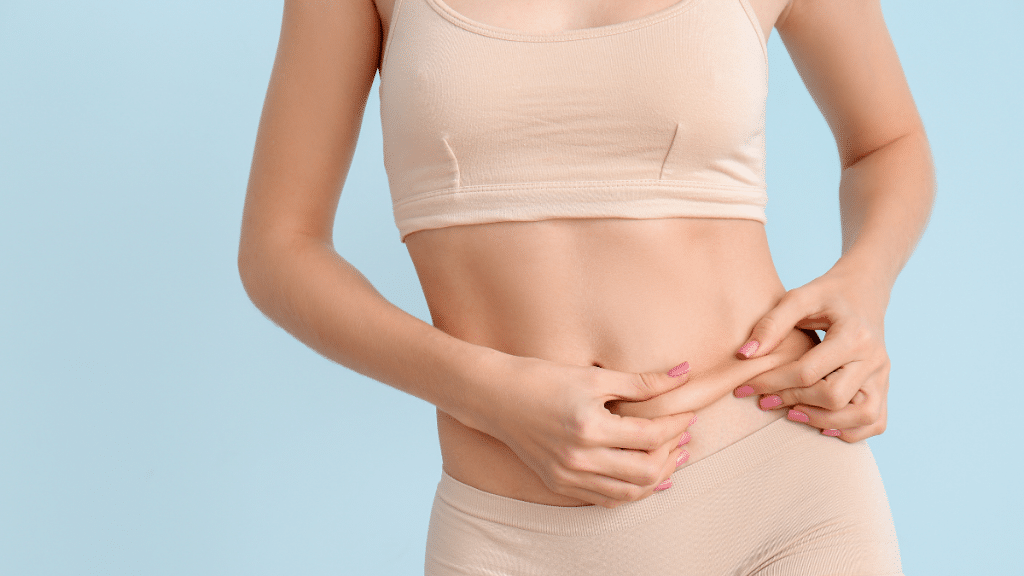 woman pinching stomach to test loose skin vs fat