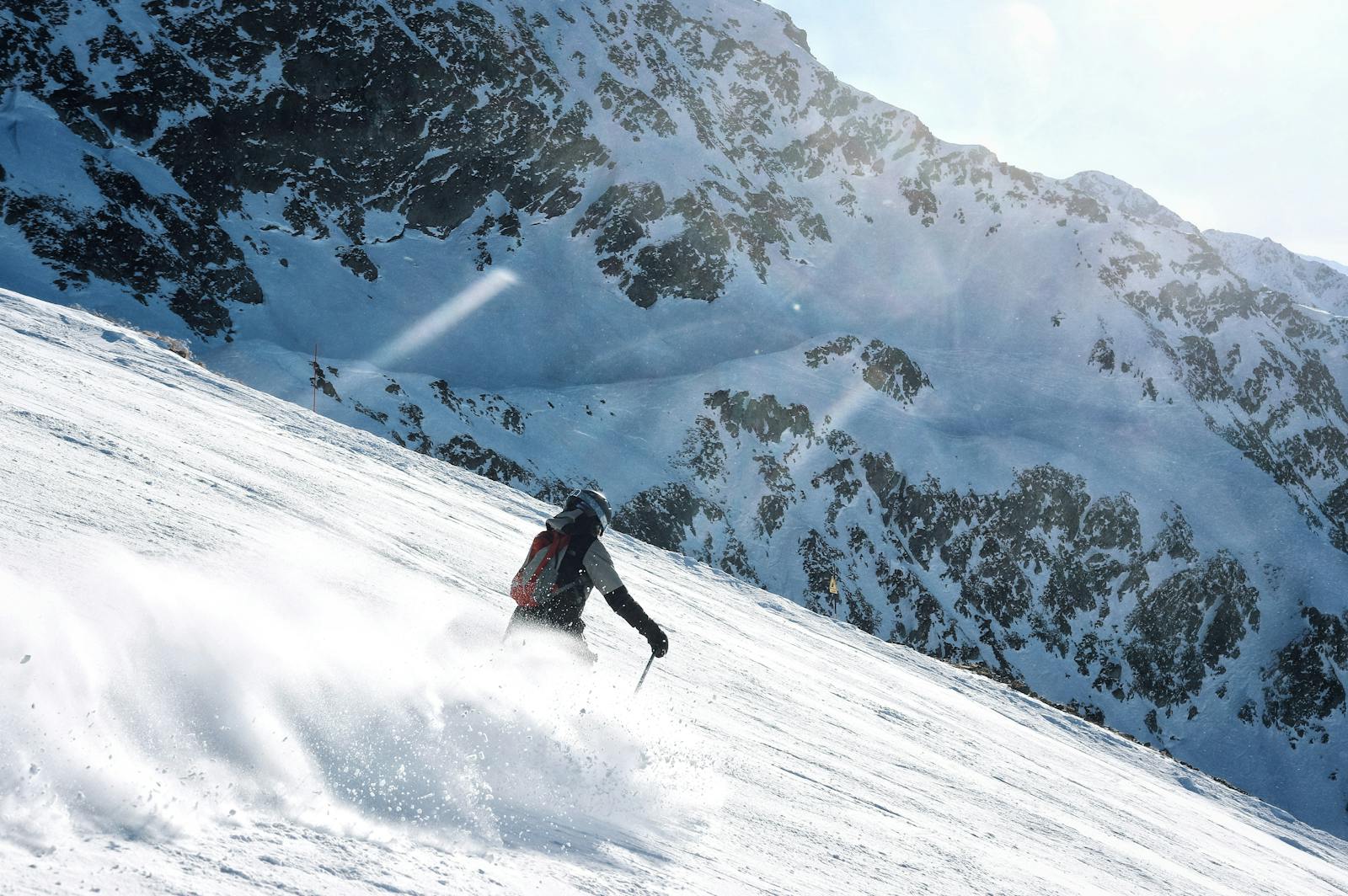 Skier descending a snowy mountain slope